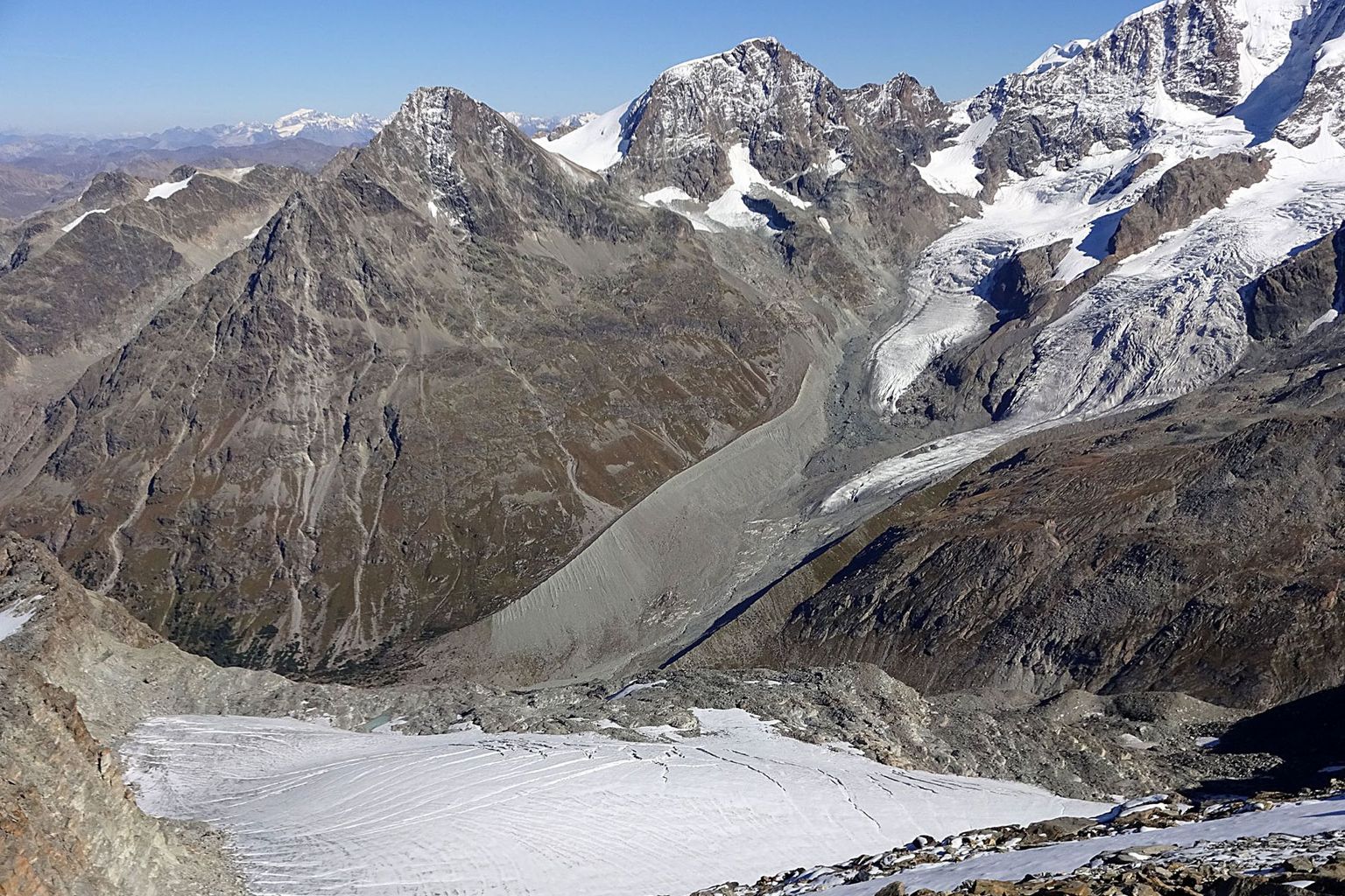Der Gletscher Vadret da Tschierva im Engadin (September 2016). Der starke Rückgang des Eises zeigt sich eindrücklich in der Bildmitte (Seitenmoränen). Seit 1850 ist gut die Hälfte der Gletschermasse in der Schweiz weggeschmolzen. Der Rückgang des Eises legt Schutt und Geröll frei und lässt neue Seen entstehen – dies verändert die Ästhetik der Landschaft. Falls wir das Klima weiterhin so beeinflussen wie bisher, werden im Jahr 2100 nur noch 20 bis 30% der heutigen Eismassen übrigbleiben. Die Schneesaison wird sich um mehrere Wochen verkürzen und die Schneegrenze um mehrere Hundert Meter ansteigen. Infrastrukturen wie Skilifte, die heute auf Permafrostböden stehen, werden ihren stabilen Untergrund verlieren. Auf dem Jungfraujoch auf rund 3500 m ü. M. schmilzt der Permafrost bereits seit einigen Jahren im Sommer. Der Verlust an Schnee und Felsstabilität wird die (Schnee-) Sicherheit in Bergregionen und den Tourismus beeinträchtigen und zu Anpassungen zwingen. Auch die Pflanzenwelt wird sich anpassen müssen – so droht beispielsweise die Fichte aus dem Mittelland zu verschwinden. Der Gletscher Vadret da Tschierva im Engadin (September 2016). Der starke Rückgang des Eises zeigt sich eindrücklich in der Bildmitte (Seitenmoränen). Seit 1850 ist gut die Hälfte der Gletschermasse in der Schweiz weggeschmolzen. Der Rückgang des Eises legt Schutt und Geröll frei und lässt neue Seen entstehen – dies verändert die Ästhetik der Landschaft. Falls wir das Klima weiterhin so beeinflussen wie bisher, werden im Jahr 2100 nur noch 20 bis 30% der heutigen Eismassen übrigbleiben. Die Schneesaison wird sich um mehrere Wochen verkürzen und die Schneegrenze um mehrere Hundert Meter ansteigen. Infrastrukturen wie Skilifte, die heute auf Permafrostböden stehen, werden ihren stabilen Untergrund verlieren. Auf dem Jungfraujoch auf rund 3500 m ü. M. schmilzt der Permafrost bereits seit einigen Jahren im Sommer. Der Verlust an Schnee und Felsstabilität wird die (Schnee-) Sicherheit in Bergregionen und den Tourismus beeinträchtigen und zu Anpassungen zwingen. Auch die Pflanzenwelt wird sich anpassen müssen – so droht beispielsweise die Fichte aus dem Mittelland zu verschwinden.